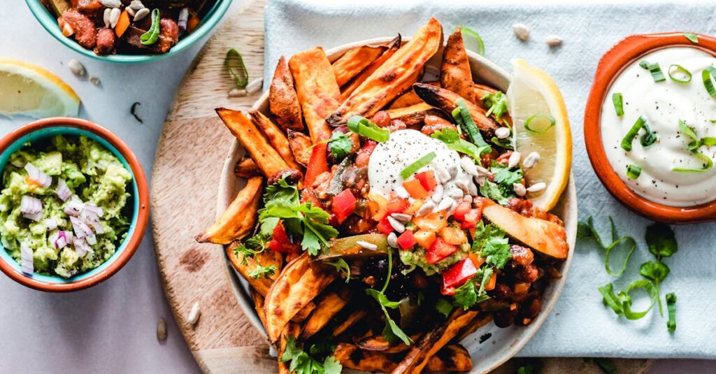 A vibrant platter of savory sweet potato fries with fresh toppings, perfect for a tasty snack.